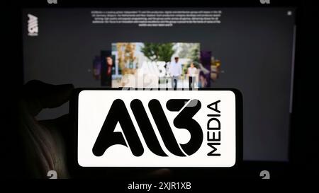 Stuttgart, Germany, 11-27-2023: Person holding cellphone with logo of British television production company All3Media Limited in front of webpage. Stock Photo