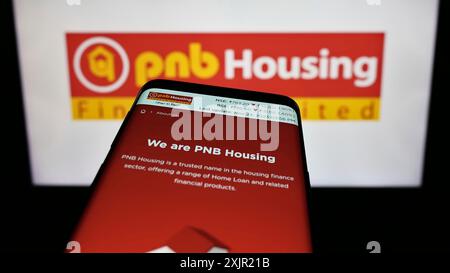 Stuttgart, Germany, 11-24-2023: Smartphone with website of Indian financial company PNB Housing Finance Limited in front of business logo. Focus on Stock Photo