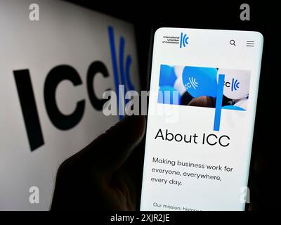 Stuttgart, Germany, 12-08-2023: Person holding cellphone with webpage of organisation International Chamber of Commerce (ICC) in front of logo. Focus Stock Photo