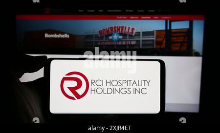 Stuttgart, Germany, 02-11-2024: Person holding cellphone with logo of US nightclub company RCI Hospitality Holdings Inc. in front of business Stock Photo