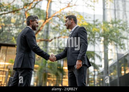 Two businessmen shaking hands outdoors. Shaking hands. Management strategy. Handshake between two businessmen. Communication of business concept Stock Photo