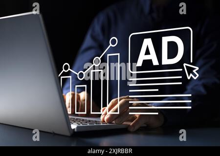 Young Caucasian man using laptop to promote his global advertising company with a creative SEO marketing strategy to optimize online presence. Stock Photo