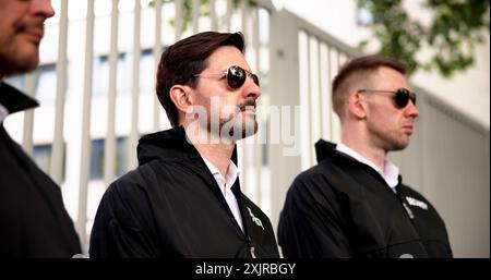 Handsome Bodyguard Protects Mature Businessman Outside Corporate Building in Sunglasses, Professionally Guarding with Private Security Services Stock Photo