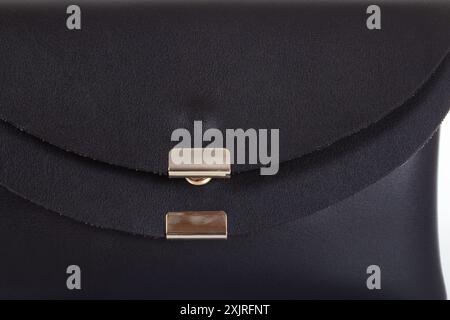 Swatch of black leather texture with golden clasp furniture accessory. Close-up of leather bag Stock Photo