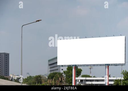 Large horizontal blank sign on a highway in Bangkok, Thailand. Traffic and sky, clipping path. A blank billboard with an elevated highway in the backg Stock Photo