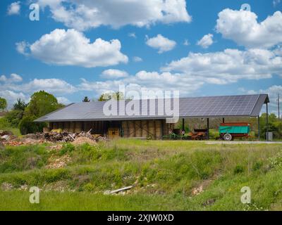 Dordogne, France - Apr 30 2024: Solar panels covering the roof of an open sided farm building in the Dordogne region of rural France. Taken on a sunny Stock Photo