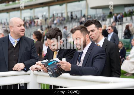 Ascot, Berkshire, UK. 12th July. 2024. Racegoers studying their racecards at Ascot Racecourse in Berkshire at the Ascot Summer Mile Property Raceday. Credit: Maureen McLean/Alamy Stock Photo