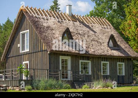 Traditional Estonian house with thatched roof - cultural heritage, Estonian national monument. Modern building Stock Photo