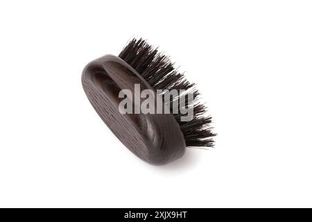 Close up view of a black wood beard brush with natural bristles on a white background in the center of the image. Facial care concept for men. Stock Photo