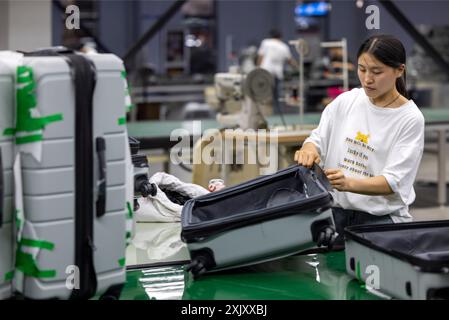SUQIAN, CHINA - JULY 20, 2024 - A worker is working at a smart luggage production line in Suqian, East China's Jiangsu province, July 20, 2024. Stock Photo