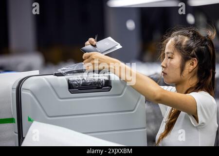 SUQIAN, CHINA - JULY 20, 2024 - A worker is working at a smart luggage production line in Suqian, East China's Jiangsu province, July 20, 2024. Stock Photo