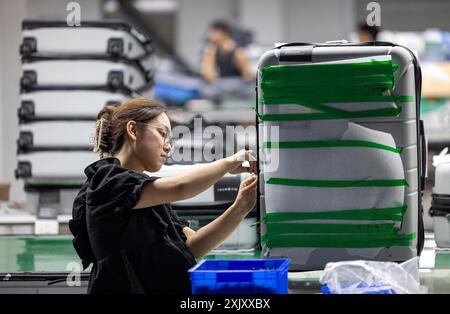 SUQIAN, CHINA - JULY 20, 2024 - A worker is working at a smart luggage production line in Suqian, East China's Jiangsu province, July 20, 2024. Stock Photo