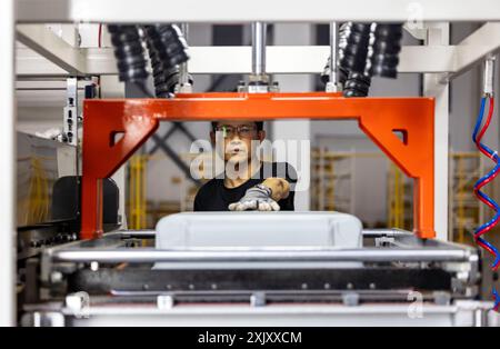 SUQIAN, CHINA - JULY 20, 2024 - A worker is working at a smart luggage production line in Suqian, East China's Jiangsu province, July 20, 2024. Stock Photo
