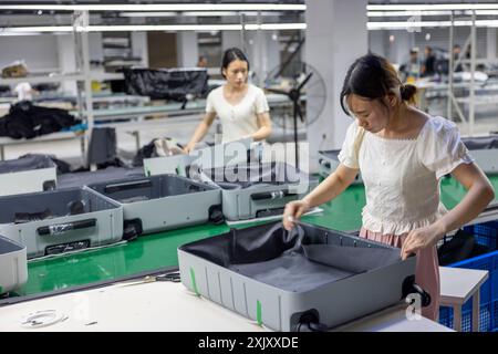 SUQIAN, CHINA - JULY 20, 2024 - A worker is working at a smart luggage production line in Suqian, East China's Jiangsu province, July 20, 2024. Stock Photo