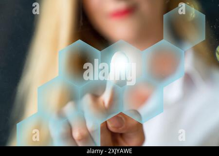 Person touching an hexagonal button on a digital interface Stock Photo