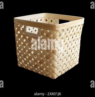 Square straw wicker goat for storing things on a wooden background. Front view Stock Photo
