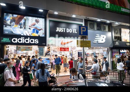 Shoppers are seen outside the American Multinational sports clothing brands Adidas, Nike, and New Balance (NB) logos and stores in Hong Kong. Stock Photo