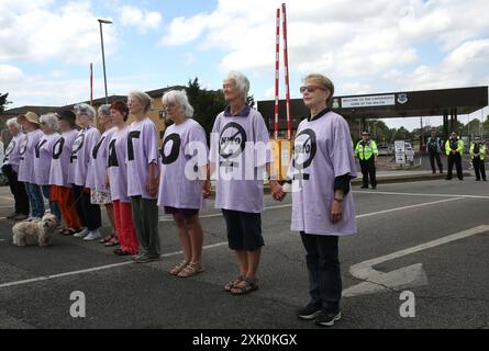 July 20, 2024, Lakenheath, England, UK: Protesters line up across the access road to the air base to hold a two minute silence for those that have died as a result of war outside the air force base in Lakenheath, during the demonstration. The protest was organised by the Campaign for Nuclear Disarmament (CND), whose supporters oppose the potential return of nuclear weapons to military bases in the UK, such as RAF Lakenheath after it was reported that the US intends to resite nuclear bombs at the base. After sustained protest nuclear weapons were removed from Lakenheath in 2008. (Credit Image: Stock Photo