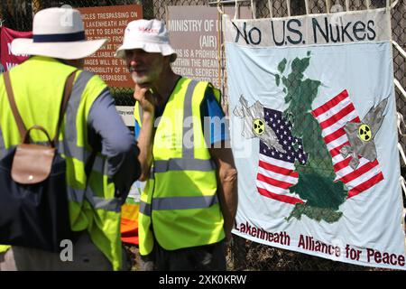 July 20, 2024, Lakenheath, England, UK: Protesters gather by a sign attached to the fencing saying ''˜No to US Nukes' outside the air force base in Lakenheath, during the demonstration. The protest was organised by the Campaign for Nuclear Disarmament (CND), whose supporters oppose the potential return of nuclear weapons to military bases in the UK, such as RAF Lakenheath after it was reported that the US intends to resite nuclear bombs at the base. After sustained protest nuclear weapons were removed from Lakenheath in 2008. (Credit Image: © Martin Pope/ZUMA Press Wire) EDITORIAL USAGE ONLY Stock Photo