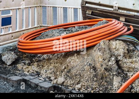 Thick rolled up fiber optic cable on a construction site by the road Stock Photo