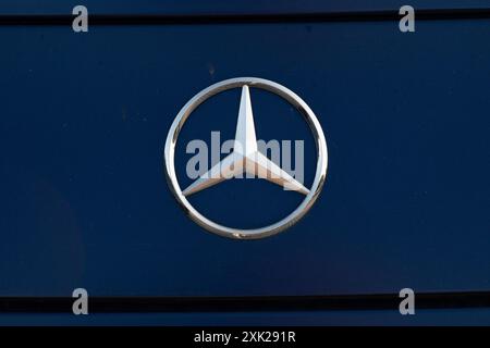 The Daimler Mercedes Benz logo on a dark blue background Stock Photo