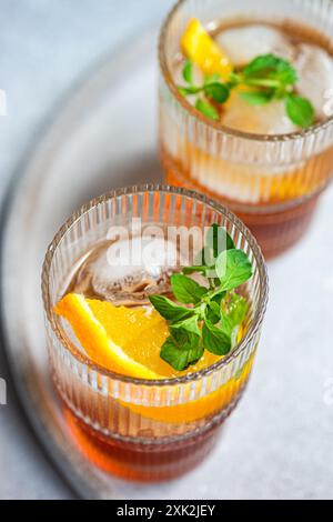 An invigorating summer cocktail featuring cherry liqueur mixed with tonic, served in a stylish glass with ice cubes, adorned with a fresh orange slice Stock Photo