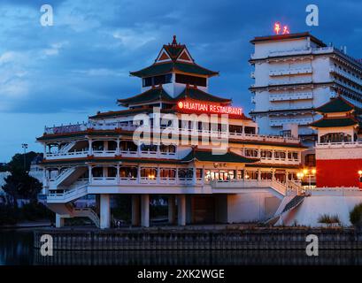 The night view of the chinese-inspired architecture of the Huatian Chinagora restaurant with curved roof corners and traditional glazed roof tiles. Stock Photo