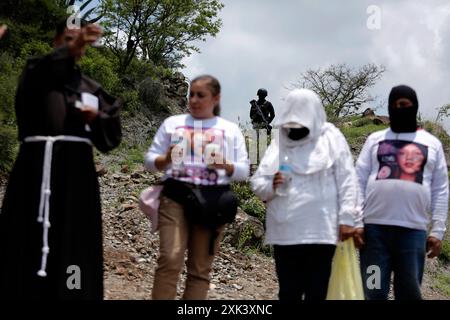 Queretaro, Mexico. 19th July, 2024. A member of the Guardia Nacional guards a religious ceremony. During a search day, the Desaparecidos Querétaro collective placed a cross that symbolizes peace on a property in the community of Santa Barbara de la Cueva, in the municipality of San Juan del Río, Querétaro, where 3 bodies have previously been found. They have already been identified. Canines from the National Guard also participated in the search. (Photo by Cesar Gomez/SOPA Images/Sipa USA) Credit: Sipa USA/Alamy Live News Stock Photo