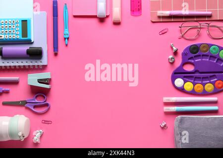 Frame made of school supplies with paint palette on pink background. Top view Stock Photo