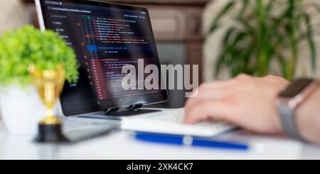 Programmer working with a computer in the office. Close-up of a man's hands typing on a keyboard. Abstract IT Stock Photo