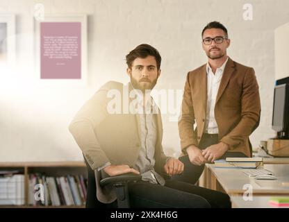 Small business, businessmen and portrait in office for design, creativity and working at computer. Web designers, desk and face in workplace for Stock Photo
