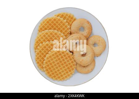 Variety of cakes and waffles in ceramic plate isolated on a white background. Yellow romantic biscuit. Top view. Stock Photo