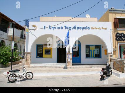 KALYMNOS, GREECE-JULY 16,2013:Scooters parked in front of Hellenic Post aka Greek Post Office Building Stock Photo