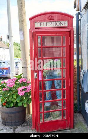 Old style (K6) red phone box (grade 2 listed) outside former post office in Great Eccleston village centre Stock Photo