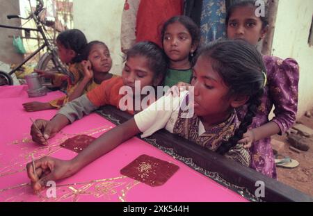 children at a Family Factory of hand made Batik Textile print at work in the city of Mysore in the Province of Karnataka in India.  India, Mysore, Mar Stock Photo