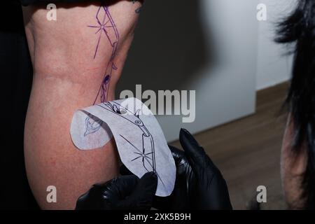 Transferring tattoo design to the skin with the tracing Stock Photo