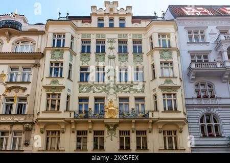 Building on Karlova 178/22 with outstanding art nouveau facade was designed by the architect Osvald Polívka year 1905. The golden sculpture of a girl Stock Photo