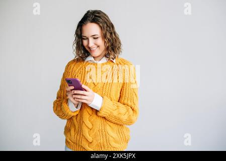 Busy Young Businesswoman Using Smartphone. Young businesswoman, manager, or professional using her smartphone. She is engaged in corporate tasks Stock Photo