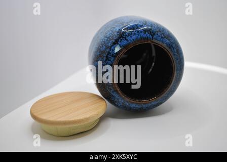 Blue And Brown Ceramic Jar With Wooden Lid On White Surface Stock Photo