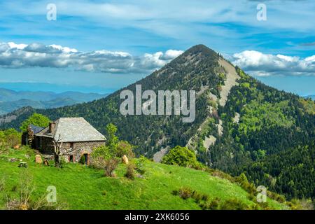 Stone Cottage Nestled in the Ardèche Mountains With Dome-Shaped Volcanic Peaks, Ardeche Regional Natural Park, Auvergne-Rhone-Alpes,  France Stock Photo