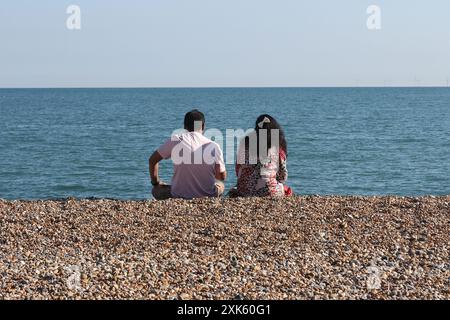 A couple sitting on Brighton beach Stock Photo