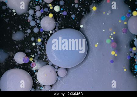 A myriad of oil droplets intermingling with water, creating a mesmerizing effect reminiscent of a galaxy. Stock Photo