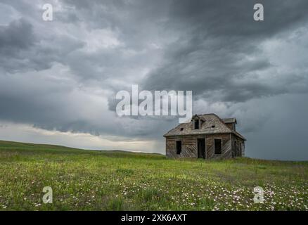 Storm clouds over an old abandoned house on the prairie near Coronach, Saskatchewan, Canada Stock Photo
