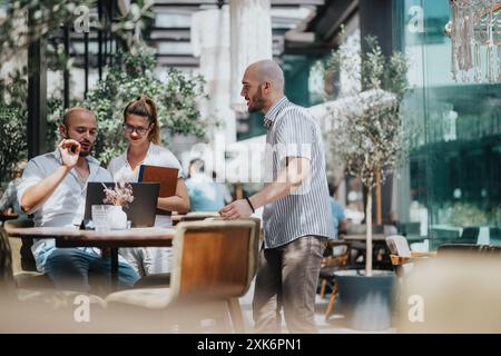 Business workers collaborating together in a coffee bar, brainstorming and sharing ideas for remote project solutions Stock Photo