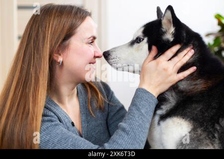 Woman bonding with her husky dog at home Stock Photo