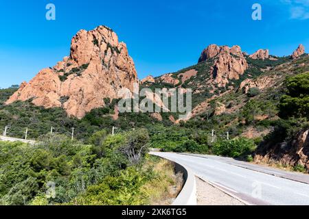 Views along Corniche d’Or or Corniche de l’Esterel beautiful coastal road, crystalline blue sea and sky combined with reddish color of Massif de l’Est Stock Photo