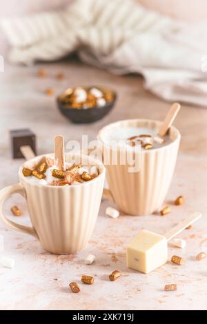 Two cups with hot chocolate dipping sticks and marshmallows, vertical Stock Photo