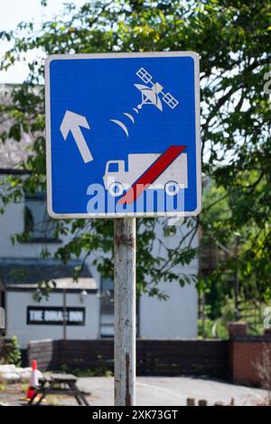 Wales, UK. A traffic information sign advising lorries and other large vehicles to ignore Sat Nav advice to take the unsuitable narrow road ahead Stock Photo