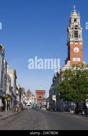 View down High Street in Colchester, Essex. The Town Hall has a tower 192 feet tall. In the distance is a Victorian water tower known as Jumbo. Stock Photo