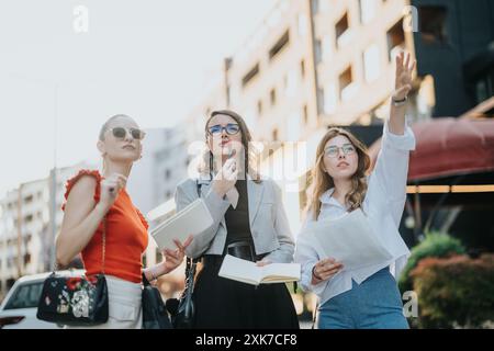 Three businesswomen discussing and planning outdoors in a modern urban setting Stock Photo
